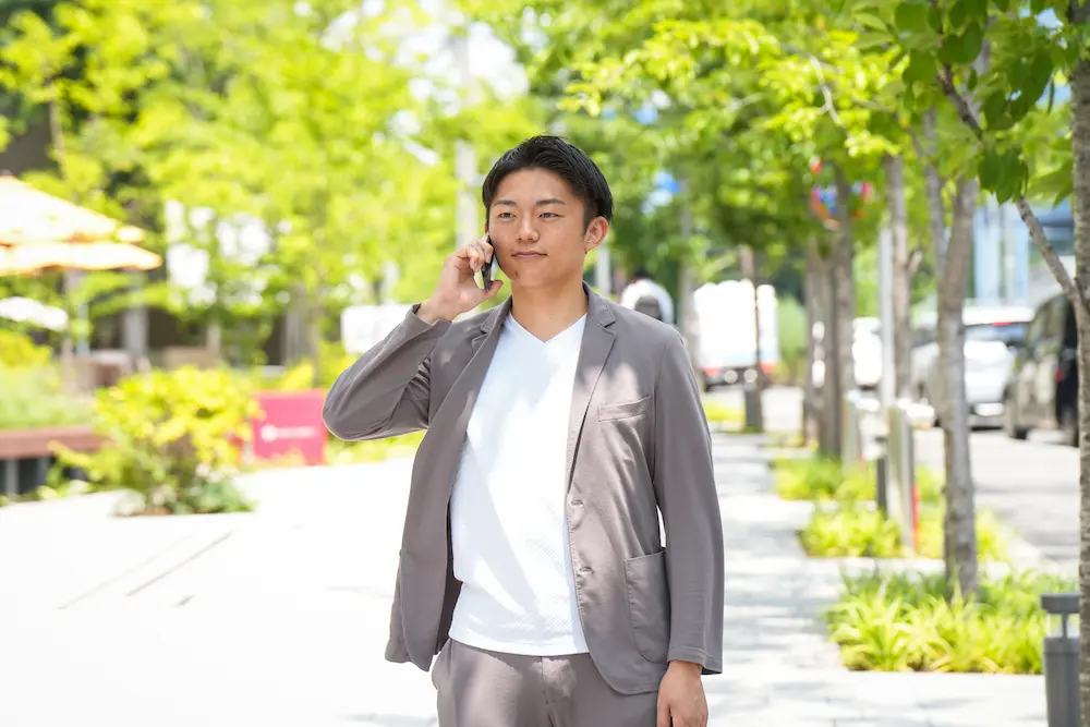 街なかで電話をする代表の中村圭介